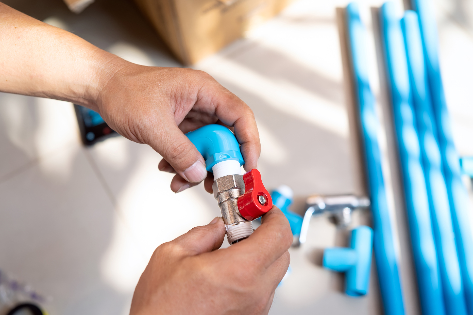 Plumber preparing a threaded shut-off valve with thread tape